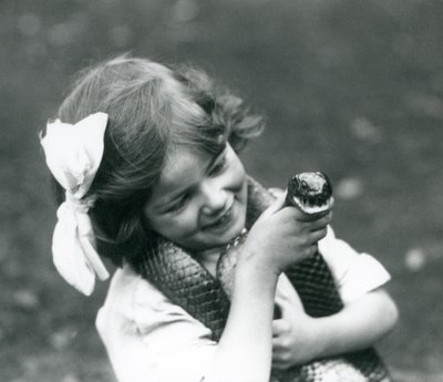 Nuori tyttö Betty, jolla on itäinen indigokäärme, Lontoon eläintarha, 1924 tekijältä Frederick William Bond