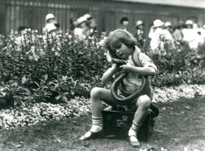 Nuori tyttö Betty pitelee itä-indigo-käärmettä istuessaan nahkaisen arkun päällä, Lontoon eläintarha, 1924 tekijältä Frederick William Bond
