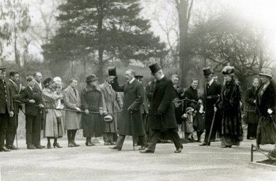 Kuningas Yrjö V nosti hattua seurueensa edessä olevalle väkijoukolle vieraillessaan Lontoon eläintarhassa avatakseen virallisesti akvaarion huhtikuussa 1924 tekijältä Frederick William Bond