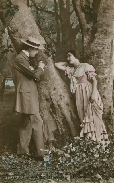 Postikortti rakastavaisista, jotka veistävät sydämen puuhun, lähetetty vuonna 1913 (käsinvärinen kuva) tekijältä French Photographer