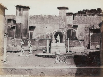 Osittainen näkymä Pompejissa sijaitsevan Marcus Lucretiuksen talon korotettuun puutarhaan, joka on koristeltu marmoripatsailla ja hermeillä. Keskellä suihkulähde kapealla. Taustalla katkelmia seinämaalauksista tekijältä Giorgio Sommer