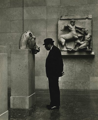 Mies katselee valokuvia British Museumissa Lontoossa 1950-luvulla. tekijältä Godfrey Macdominic