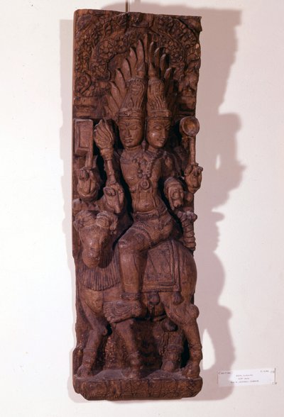 Agni, tulen jumala, kuvattu kahdella päällä (hauispää) pässissä hindujen mytologian mukaan. Puuveistos 1600-luvulta. Pariisi, Musée Guimet. tekijältä Indian School