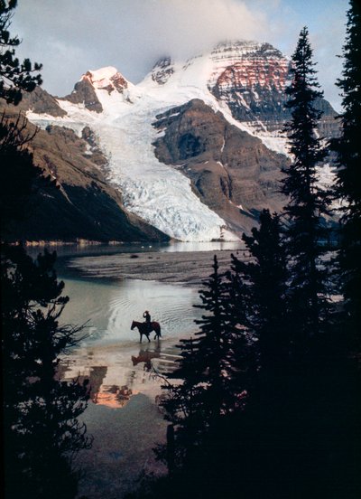 Yksinäinen hevonen ja ratsastaja pohtivat Kanadan korkeimman huipun juurella sijaitsevaa järveä. Mount Robson... tekijältä James L Stanfield