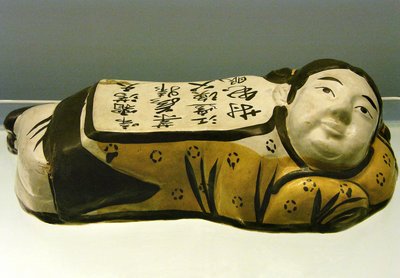 Keraaminen, lapsen muotoinen tyyny, jossa on yömaisemaa tuova runo, Cizhousta, Jin-dynastiasta (1115-1234), Shanghain kansallismuseosta. Valokuvaus, Leonard de Selva, Kiina, 2006. tekijältä Jin Dynasty Chinese School