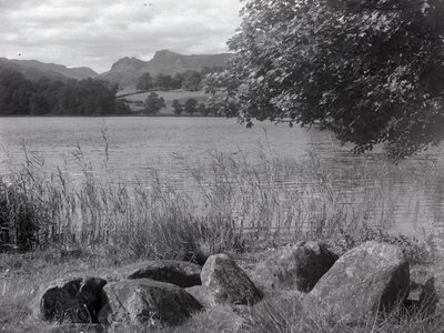 Näkymä Loughrigg Tarnin poikki, etualalla on maahan upotettuja kiviä. tekijältä Joseph Hardman