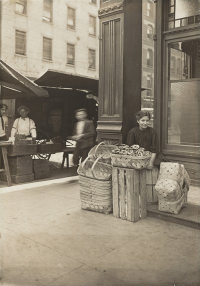 Lena Lochiavo - 11-vuotias korien ja rinkeleiden myyjä Sixth Streetin torilla saluunan sisäänkäynnin edessä, Cincinnati, Ohio tekijältä Lewis Wickes Hine