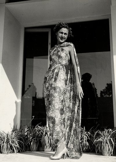 Mallilla on yllään pitkä mekko, jossa kukkakuvio on couture house "Graldi" luoma. Tuotetta täydentää samasta kankaasta valmistettu vaippa. (m/w kuva) tekijältä Luis Bogino