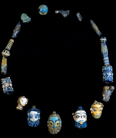 Lasitahnasta valmistettu kaulakoru riipuksilla, jotka kuvaavat parrakkaita päitä, alun perin Olbiasta, nyt säilytetty Cagliarin kansallisessa arkeologisessa museossa tekijältä Phoenician Phoenician