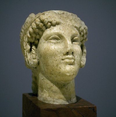 Tytön pää (Kore), veistos roomalaisesta hellenistisesta kaudesta (3. 2. vuosisata aikakautemme jälkeen), erittäin ilmeikkäät kasvot, näkyvät poskipäät itään, hymy, kiharat hiukset, arkaainen Ionien tyyli 6. vuosisadalla ennen meidän aikakautta, joka jatkui tekijältä Roman