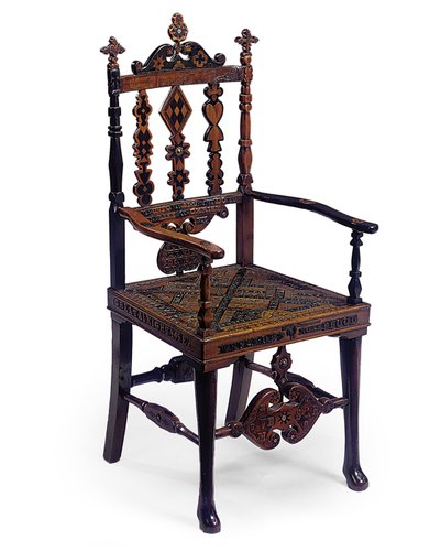 Upotekoristeinen ja kaiverrettu avoin nojatuoli, johon on koodattu tilkkutäkki erilaisia lauseita, 1800-luvun alku (suon tammi ja marjakuusi epäjaloisella metallilla) tekijältä Scottish School
