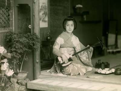 Muotokuva japanilaisesta naisesta, joka soittaa shamisenia noin 1900 - 1915 (valokuva). tekijältä Teijiro Takagi