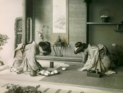 Kaksi japanilaista naista perinteisessä asussa tervehtimässä toisiaan ennen teeseremoniaa, noin 1900 - 1915 (valokuva). tekijältä Teijiro Takagi