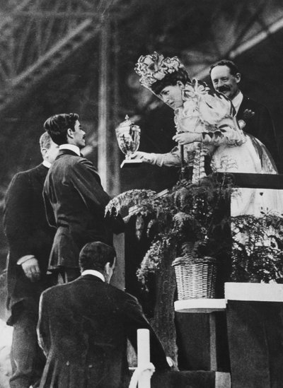 Kuningatar Alexandra luovuttaa Dorandolle erikoiskupin hänen suurenmoisen ponnistuksensa voittaa olympiamaratonin heinäkuussa 1908 muistoksi. tekijältä Thomas E. and Horace Grant Grant