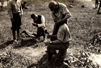 Itävaltalaiset vangit ensimmäisen maailmansodan aikana Bagnaria Arsassa, Udinen, Italiassa; etualalla sotilas ajelee toverinsa, 02.04.1916 (b/w kuva) tekijältä Ugo Ojetti