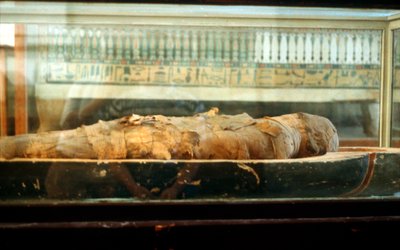 Muumio kääritty siteisiin ja makaa arkun pohjalla, muinainen egyptiläinen tekijältä Unbekannt