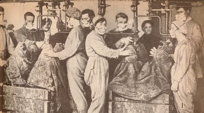 Sotatarviketyöntekijät, jotka käyttävät hengityssuojaimia täytön aikana, myydään trinitrotolueenilla T.N.T., c1916, 19 tekijältä Unbekannt