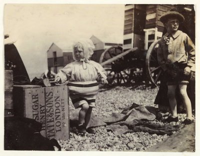 Kaksi lasta uimakoneilla, n. 1895, Tilannekuva kahdesta lapsesta meren rannalla seisomassa uimakoneiden joukossa rannalla tekijältä Unbekannt
