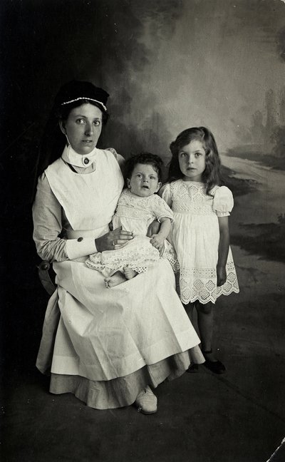 "Sairaanhoitaja" poseeraa lasten kanssa 1920-luvulla. tekijältä William M. Timlin