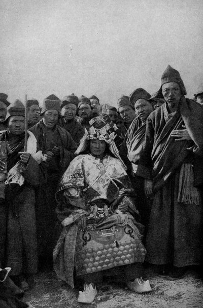 Tiibet. Taikuri täydessä asussa ja ihaileva munkkijoukko. 1920 tekijältä Unbekannt