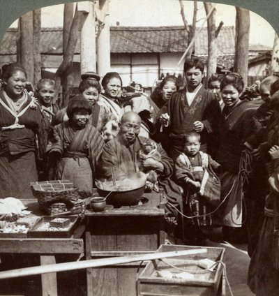 Katutaiteilija apinan kanssa huvittelemassa yleisöä, Kobe, Japani, 1896. tekijältä Underwood and Underwood