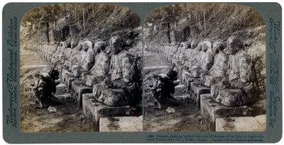 Talonpoika rukoilee valojumala-patsasrivin edessä, Daiya-joki, Nikko, Japani, 1904. tekijältä Underwood and Underwood