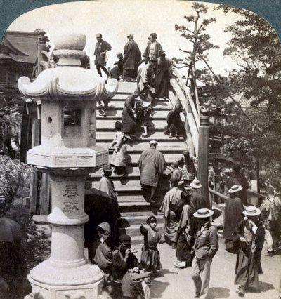 Palvojat ylittävät puolipyöreän sillan Kameidon temppeliin, katsovat pohjoiseen, Tokioon, Japaniin, tekijältä Underwood and Underwood