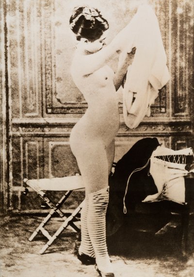 Täyspitkä alaston muotokuva pukeutuvasta nuoresta naisesta. tekijältä Unknown photographer
