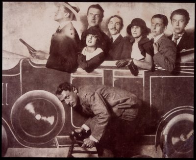 Max Morise, Simone Breton, Paul Eluard, Joseph Delteil, Gala Desnos, Andre Breton ja Max Ernst (polkupyörän selässä) Foire de Montmartre -tapahtumassa. tekijältä Unknown photographer