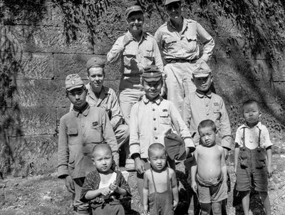 Amerikkalaiset sotilaat ja japanilainen perhe poseeraavat yhdessä Japanin antautumisen jälkeen ja... tekijältä Volkmar Wentzel