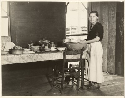 [Elizabeth Tengle keittiön pöydässä]/[Paralee Ricketts työskentelee keittiössä] tekijältä Walker Evans