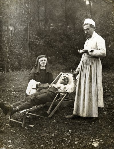 Lääkäri mittaa loukkaantuneen miehen pulssia sairaanhoitajan apuna, noin 1900 (m/v kuva) tekijältä . .