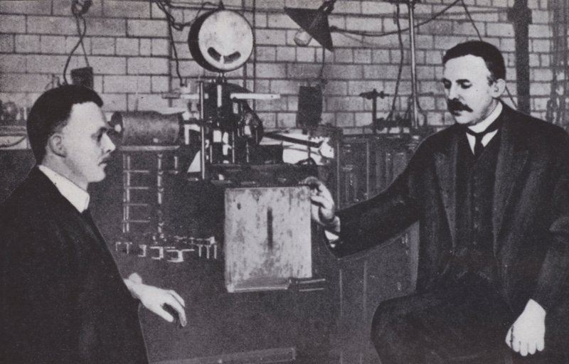 Ernest Rutherford (vasemmalla) ja Hans Geiger Manchesterin yliopiston fysiikan laboratoriossa (s/w-kuva). tekijältä English Photographer