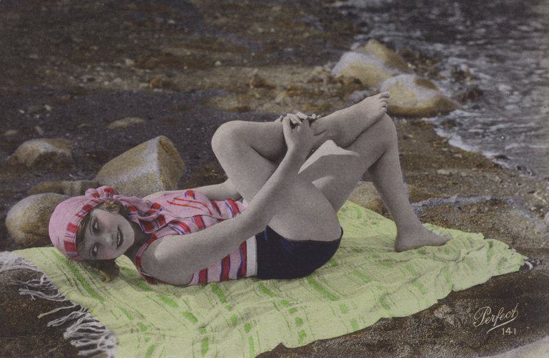Tyttö makaa pyyhkeellä rannalla (värillinen kuva) tekijältä English Photographer