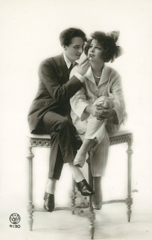 Androgyyni puku pukeutunut mies levittää huulipunaa pyjamassa pukeutuneen tytön huulille tekijältä French Photographer
