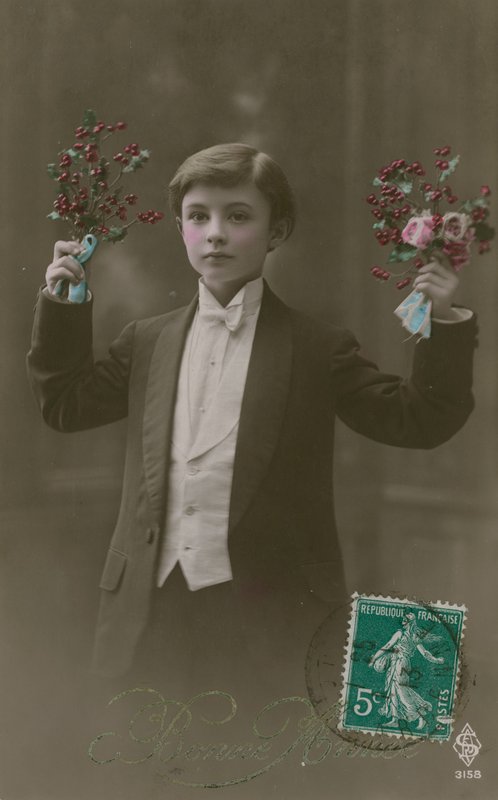 Postikortti valkoisella solmiolla ja hännällä pukeutuneesta pojasta, jolla on kukkia ja marjoja, lähetetty vuonna 1913 (käsinvärinen kuva) tekijältä French Photographer