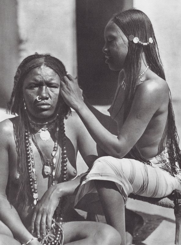 Afrikka: Sudanilaiset naiset punovat hiuksia (s/w-kuva). tekijältä Hugo Adolf Bernatzik