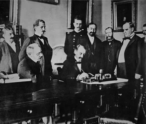 Presidentti William Mckinley (1843-1901) on todistamassa rauhanpöytäkirjan allekirjoittamista, joka päätti sodan Espanjan kanssa