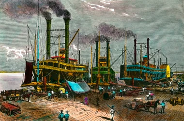 Ladataan puuvillaa höyrylaivoille Mississippillä New Orleansiin (New Orleans). Kaiverrus 1800-luvulta. Yksityinen kokoelma