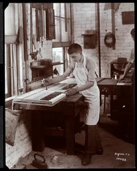 Nuori mies työskentelee Harrington Piano Co:n tehtaalla, 1907 (hopeagelatiinipaino)