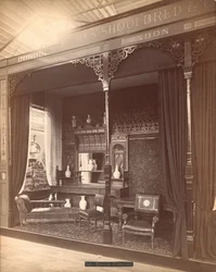 Eksibit ng James Shoolbred & Co. -- Pangunahing Gusali, eksena sa Parlor na binubuo ng sideboard at salamin na may mga plorera sa at sa harap, mga upuan, mesa, at sopa. Sa sahig ay may carpet at natatakpan ng floral wallpaperfinn ang mga dingding