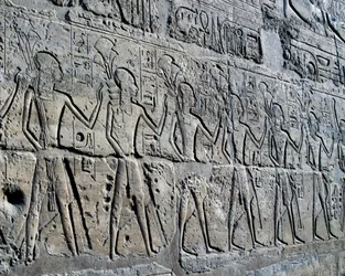 Kaivosalueita symboloivia hahmoja tuomassa veronsa jumalalle, reliefi, Ramesses II:n sisäpiha, Amunin temppeli (Unescon maailmanperintöluettelo).