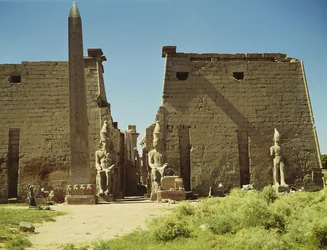 Julkisivu ja ensimmäinen pyloni, jossa on kaksi istuvaa Ramses II:n patsasta ja jäljellä oleva obeliski