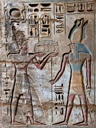 Egyptiläinen antiikki: ensimmäinen piha, yksityiskohta maalatuista reliefeistä, jotka kuvaavat faaraota kuljettamassa uhreja jumalalliselle Horukselle. Ramses III:n hautaustemppeli (1187-1156 eKr.). Luxor, Medinet Habou, Egypti