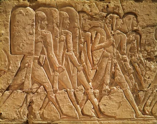 Uuden kuningaskunnan Ramses III:n ruumistemppelin (n. 1184–1153 eKr.) kohokuvio, joka kuvaa köyttä ja aseita kantavia palvelijoita