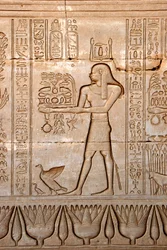 Egyptiläinen antiikki: esitys miehestä, joka tuo uhreja jumalattarelle, Hathorin temppeli, Denderah, Egypti - Egyptin sivilisaatio: mies, joka kuljettaa uhreja jumalatar Hathorille, kaiverrettu Hathorin temppelin (tai Tentyran temppelin) seinälle Denderahi