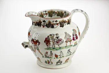 Staffordshire-kannu koristeltu harlekiinihahmoilla ja karnevaaliteemalla, 1866 (rautakivi posliini)