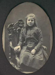 [Tyttö, jolla on sormukset, istuva, kolme neljäsosaa], 1890-luku.