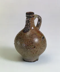 Bartmannkrug- tai Bellarmine-viinipullo koristeltu partanaamiolla, Saksa, n. 1630-40 (suolalasitettu kivitavara)