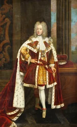 Kuningas George II:n muotokuva, kun Walesin prinssi, täyspitkä, yllään valtion kaapu ja sukkanauharitarikunnan kaulus, pitelee miekkaa vasemmassa kädessään ja koronettia viereisellä pöydällä sisätiloissa,